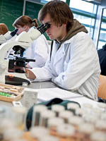 Gebruik van studentenmicroscoop op practicum; foto Dick van Aalst